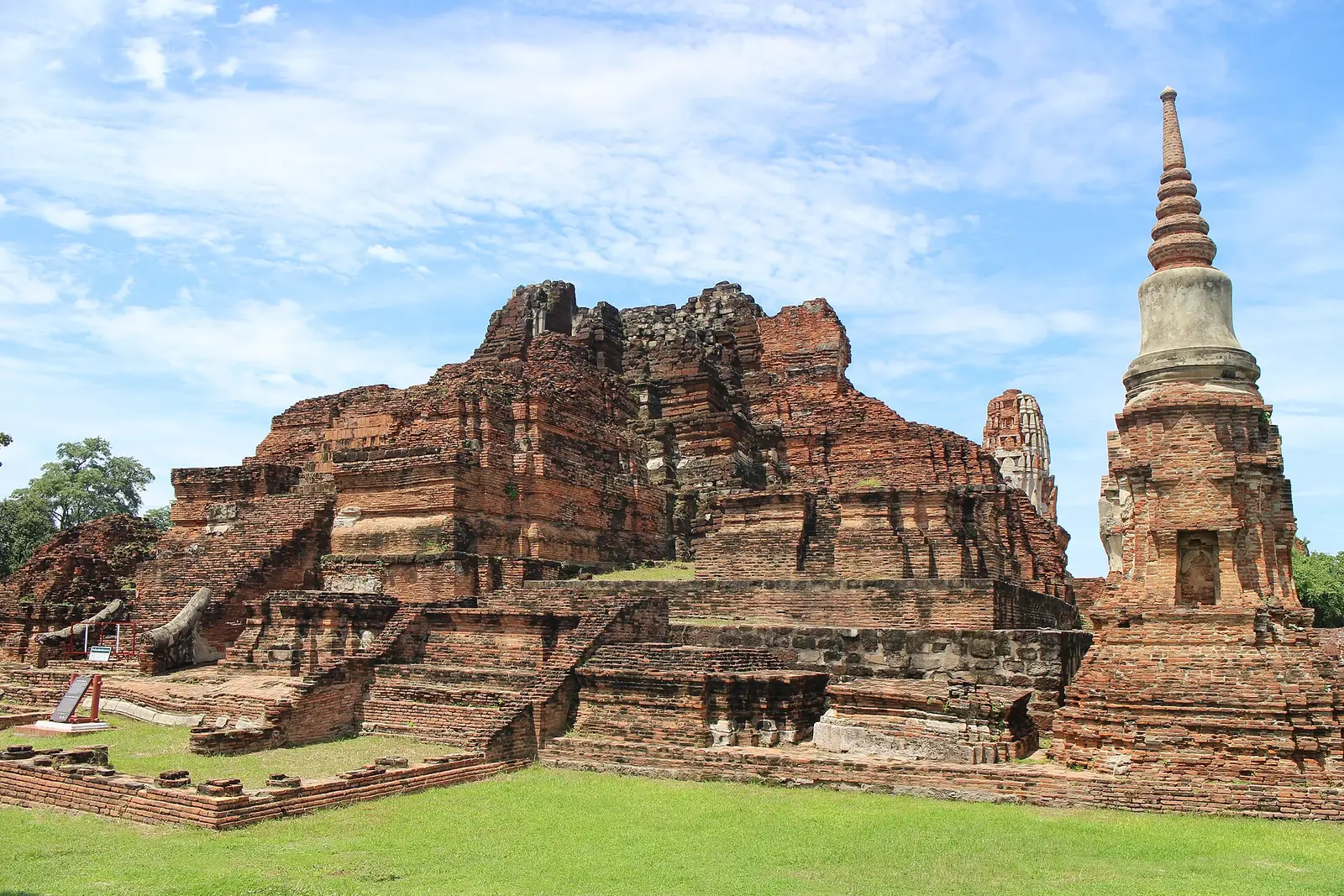 De bakstenen ruïnes van Wat Mahathat in Ayutthaya met rijen Boeddhabeelden