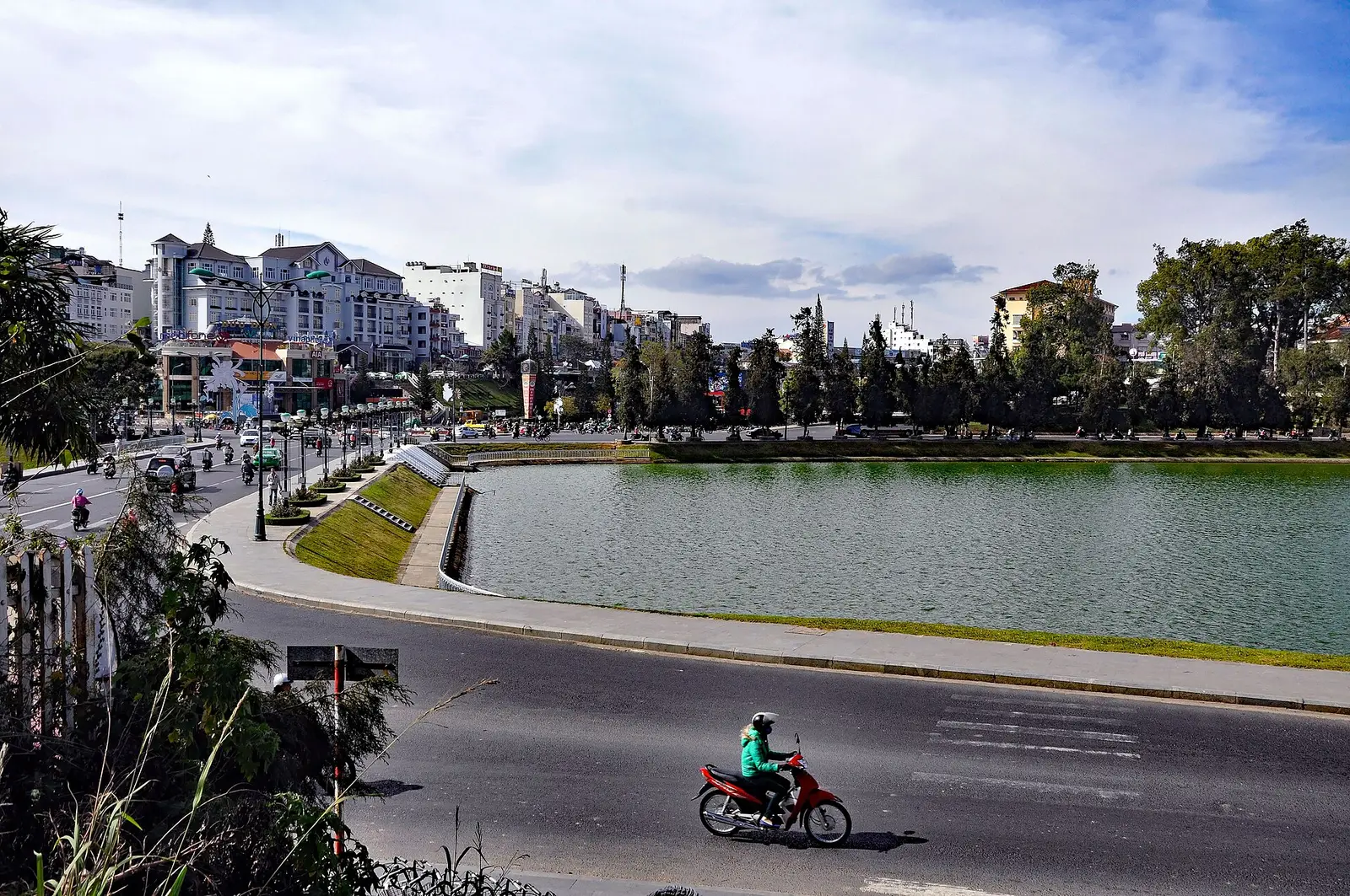 Het Xuan Huong-meer in Da Lat met groene oevers en de stad op de achtergrond