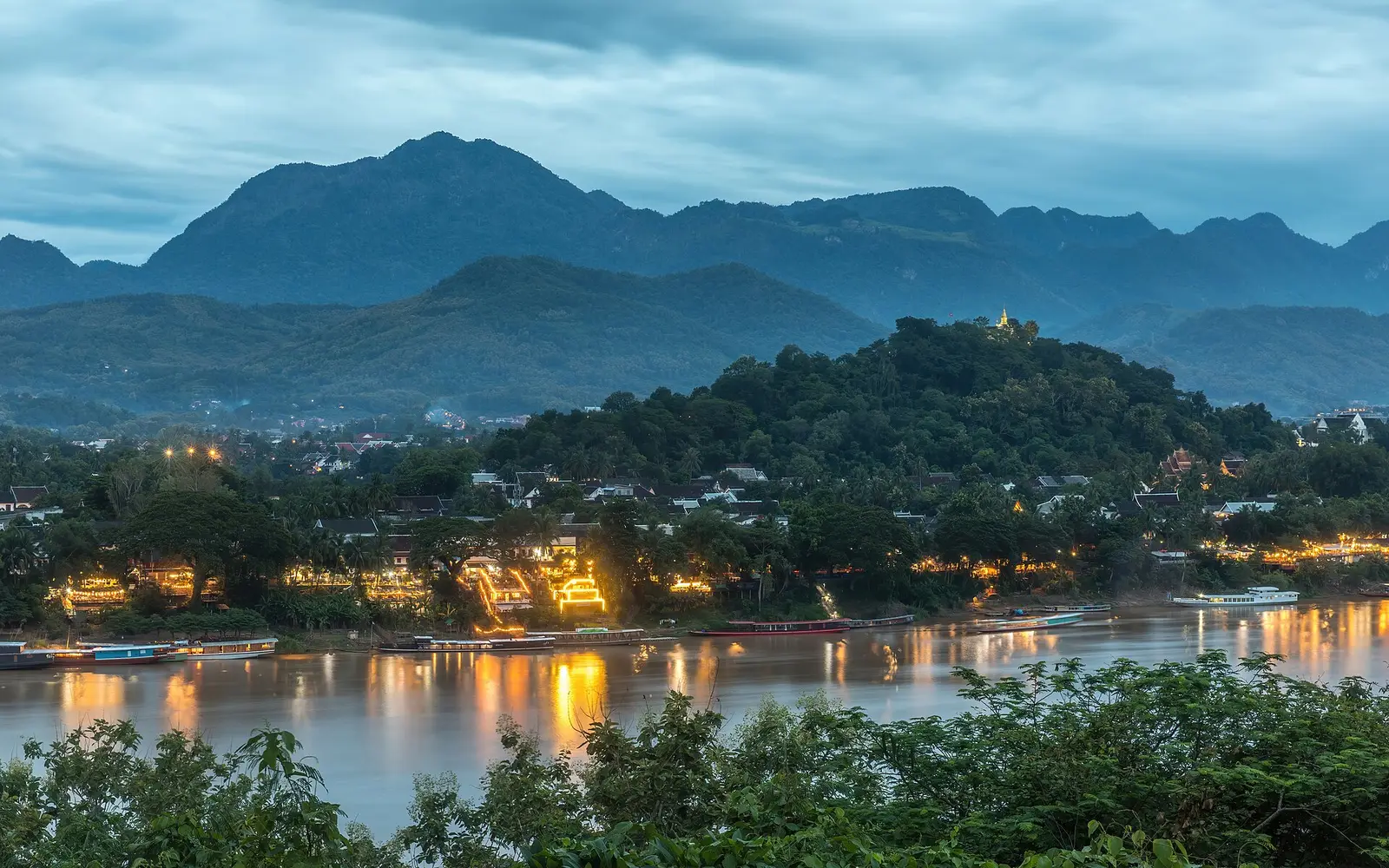 De berg Phou Si en de oever van de Mekong bij zonsondergang in Luang Prabang