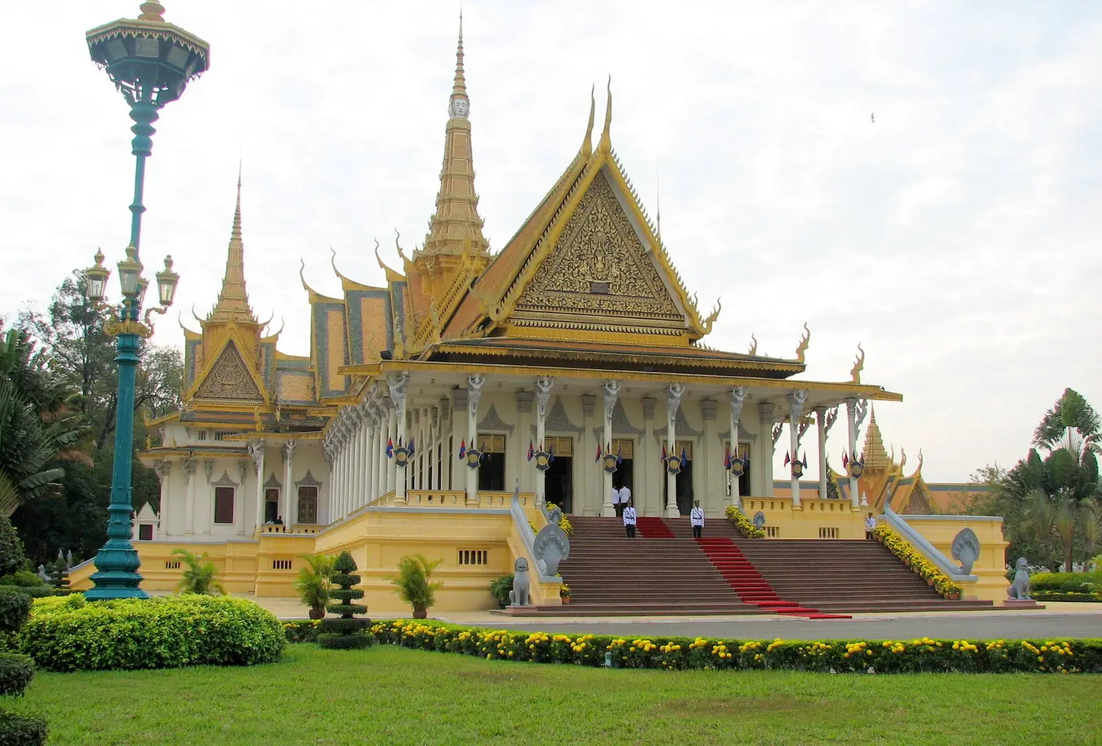 De Troonzaal van het Koninklijk Paleis in Phnom Penh met gouden spitsen en een trap met rode loper
