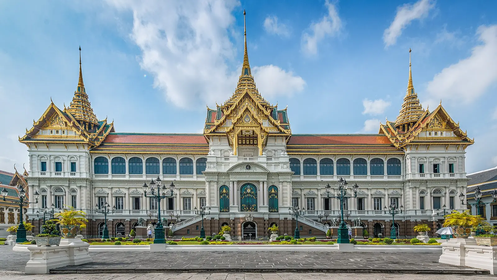 De gouden torens en dakranden van het Grand Palace in Bangkok onder een heldere hemel