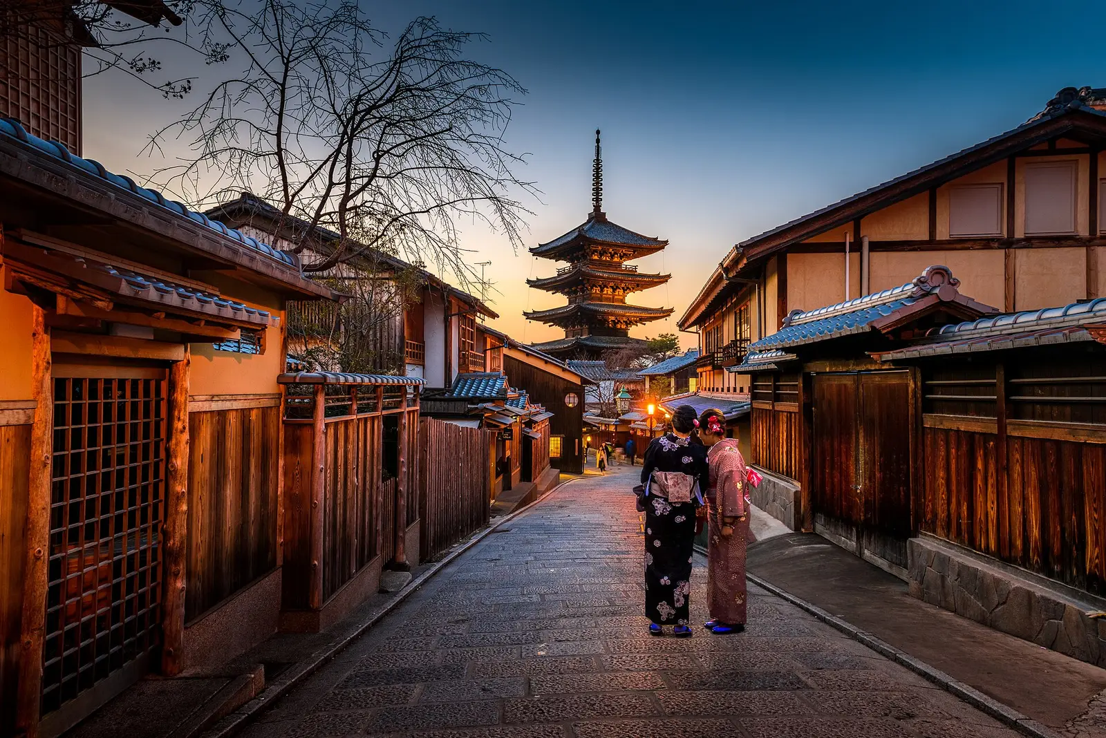 De pagode van Hōkan-ji boven een smalle straat met houten huizen in Higashiyama, Kyoto, in de schemering