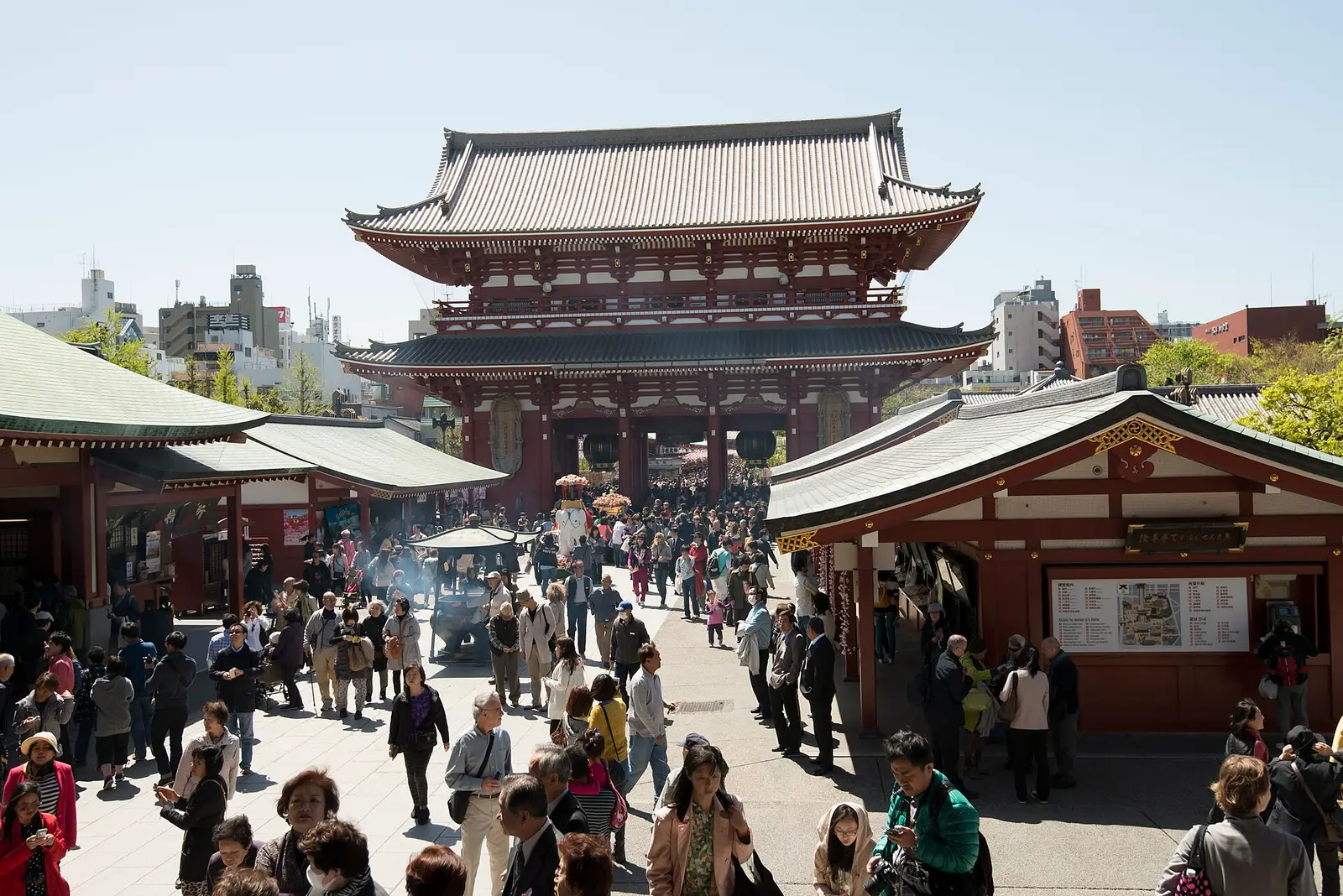 Het tempelplein van de Sensō-ji in Asakusa, Tokio, vol bezoekers, met de grote poort op de achtergrond