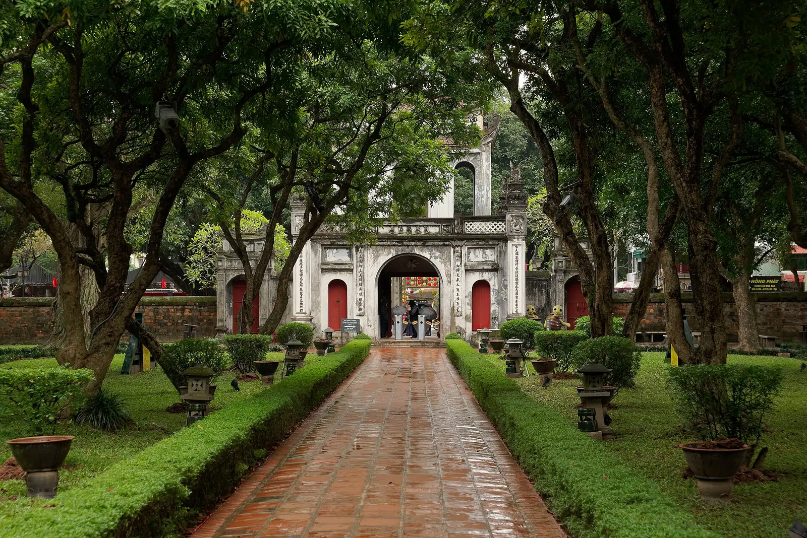 De hoofdpoort van de Literatuurtempel in Hanoi, met een tegeldak boven de houten deuren