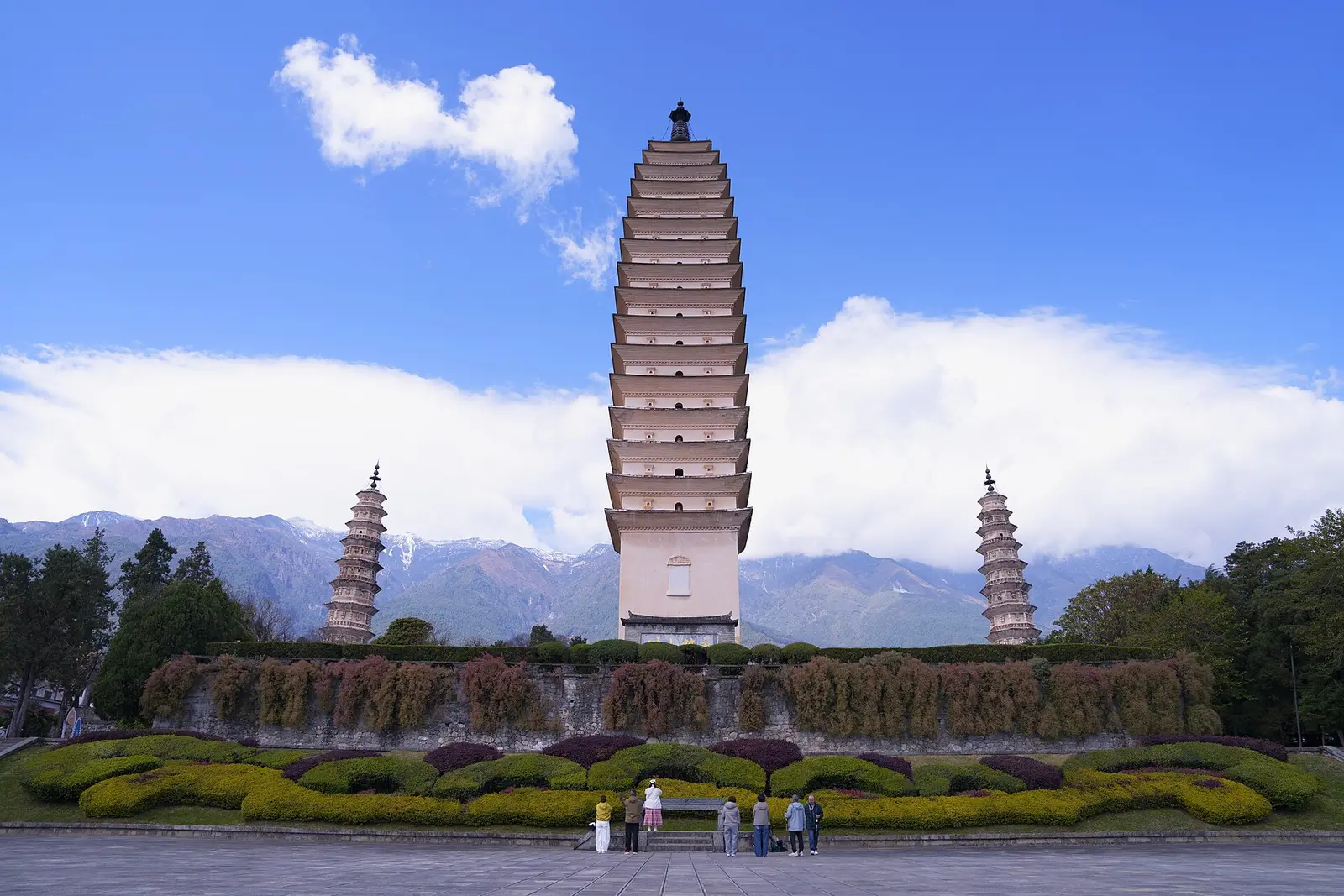De drie pagodes van de Chongsheng-tempel in Dali voor een bergrug onder een blauwe lucht